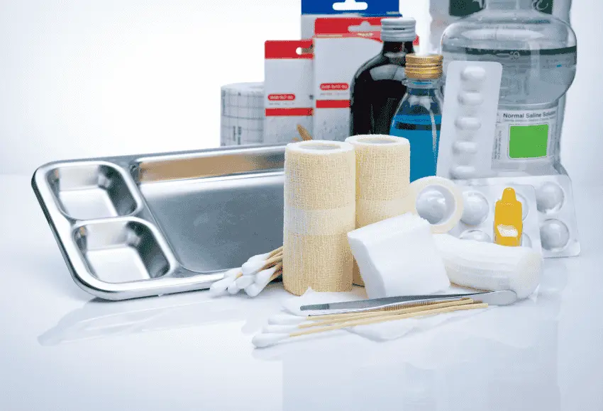 A dog wound care kit containing bandages, antiseptic, saline solution, cotton swabs, and tweezers.