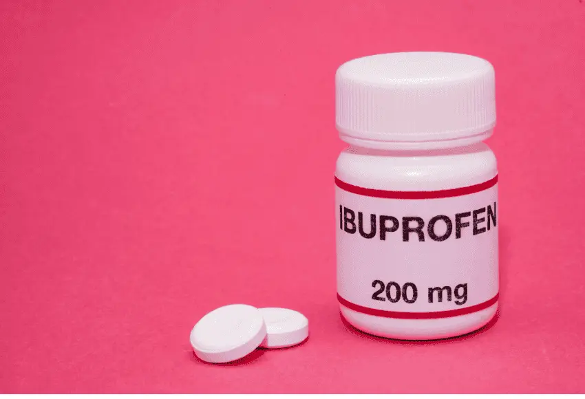 White bottle of 200mg Ibuprofen tablets on a pink background. Is ibuprofen safe for dogs?